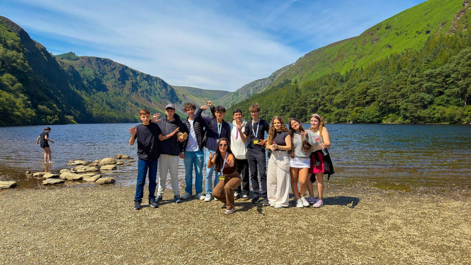 Grupo à beira do lago, entre montanhas verdes, na Irlanda