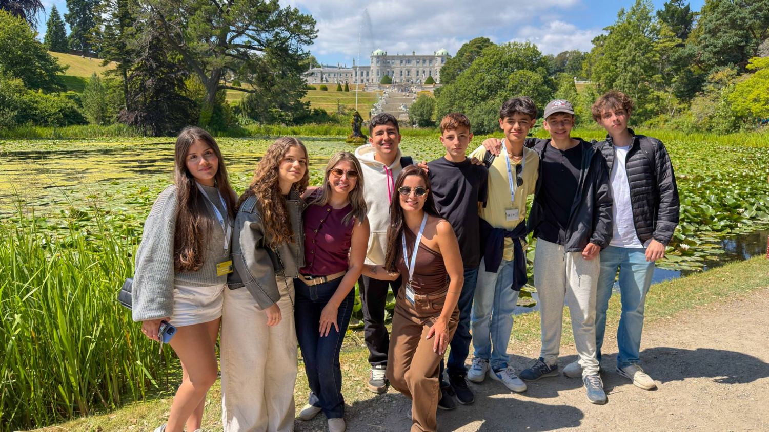 Grupo em um jardim com palácio ao fundo, na Irlanda