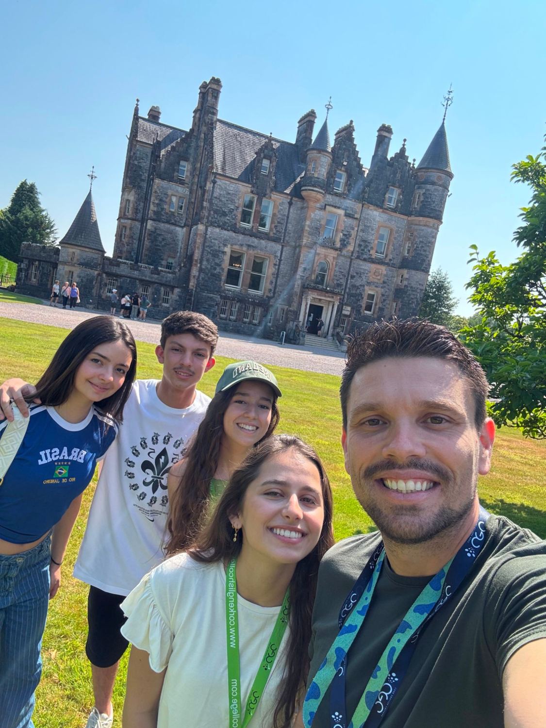 Selfie de estudantes e do líder em frente a um castelo
