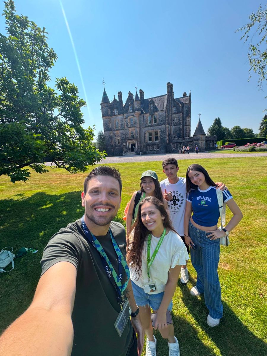 Estudantes e líder da Destino Certo sorrindo em frente ao castelo, na Irlanda
